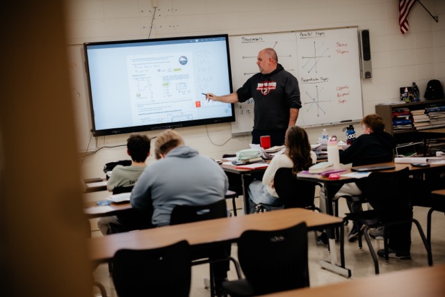 HS Math teacher presents on interactive flat panel in the front of class